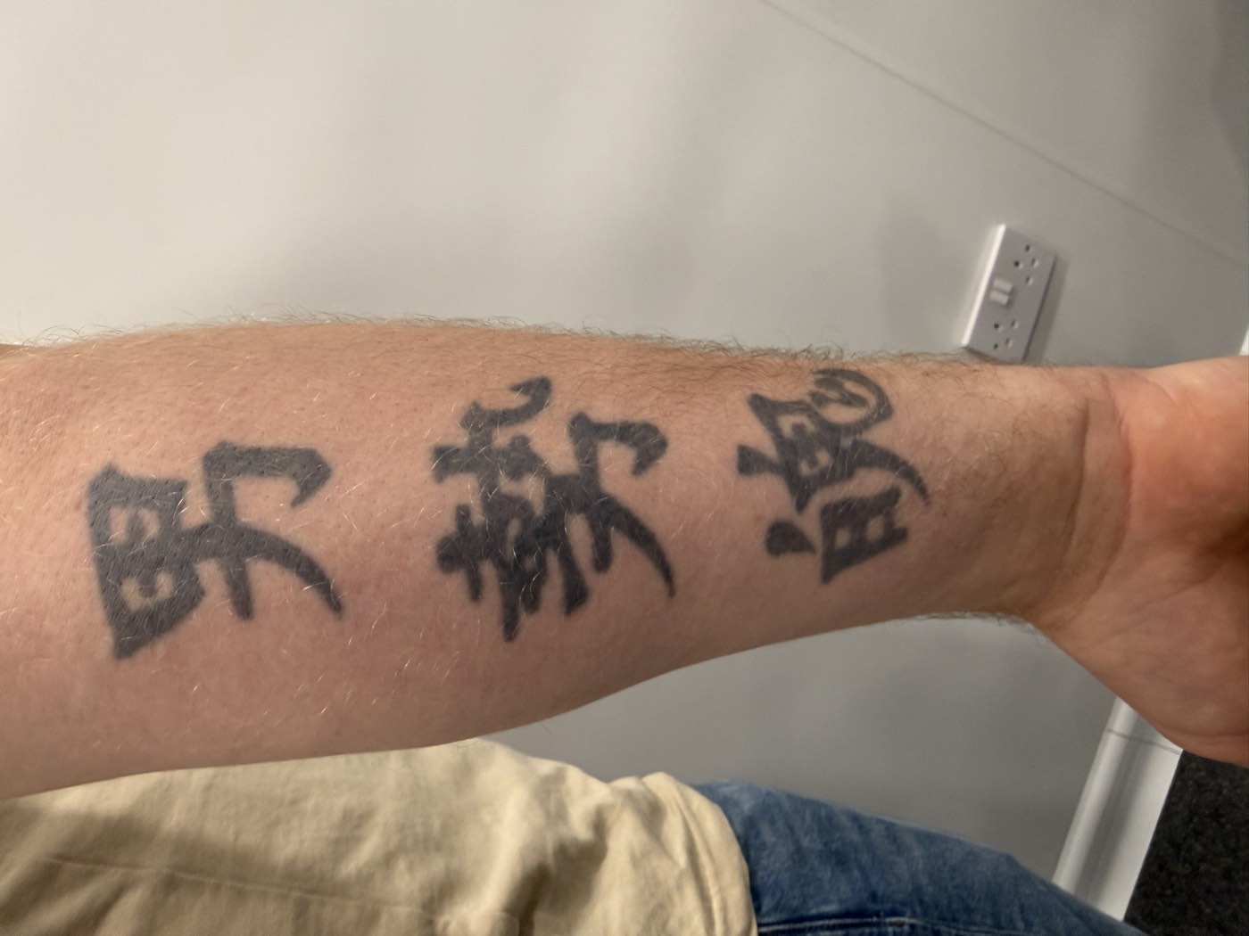 Forearm lettering tattoo before treatment